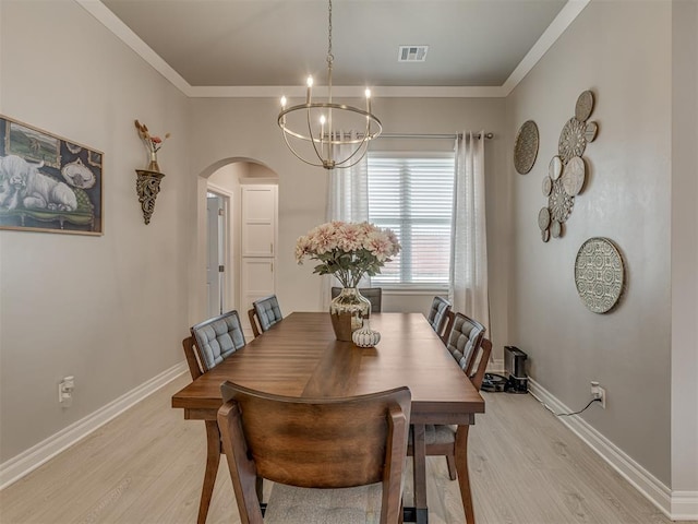 9312 Taggert Ln, Yukon, OK 73099 - dining space featuring arched walkways, light wood-style flooring, a chandelier, baseboards, and crown molding