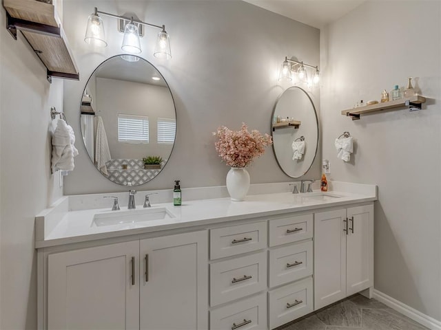 9312 Taggert Ln, Yukon, OK 73099 - bathroom featuring double vanity, marble finish floors, and baseboards
