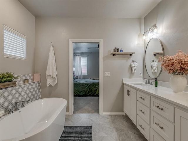 9312 Taggert Ln, Yukon, OK 73099 - ensuite bathroom featuring a freestanding bath, double vanity, decorative backsplash, and baseboards