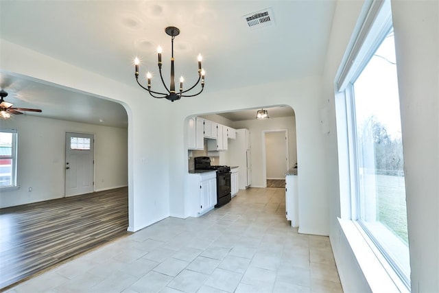 kitchen with ceiling fan with notable chandelier, white cabinetry, and black range with gas cooktop