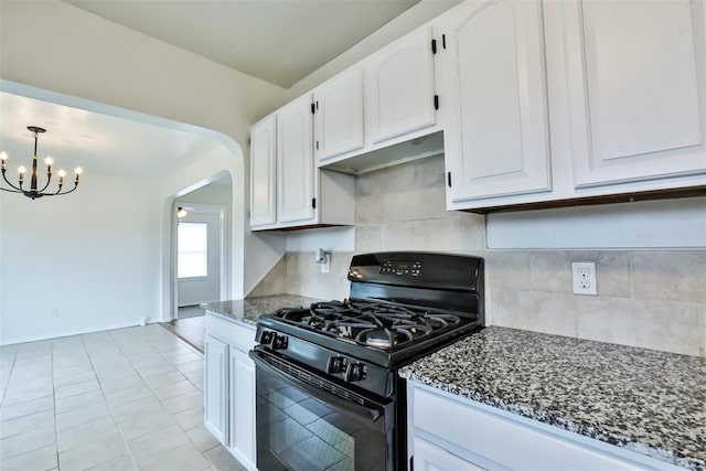 kitchen with white cabinetry, dark stone countertops, a chandelier, light tile patterned floors, and black range with gas stovetop