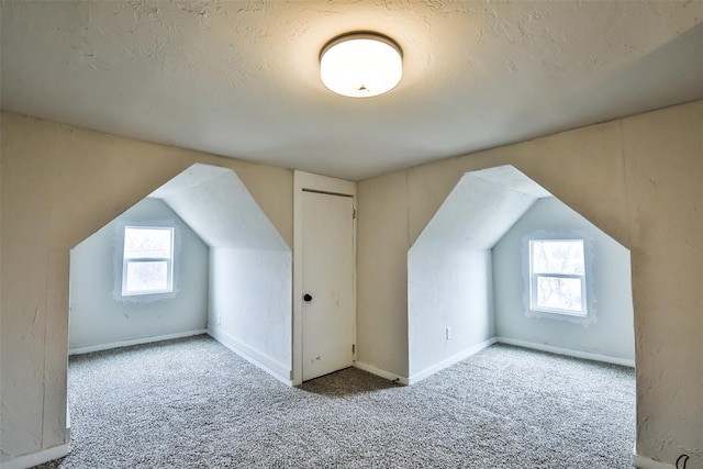 additional living space featuring lofted ceiling and light colored carpet