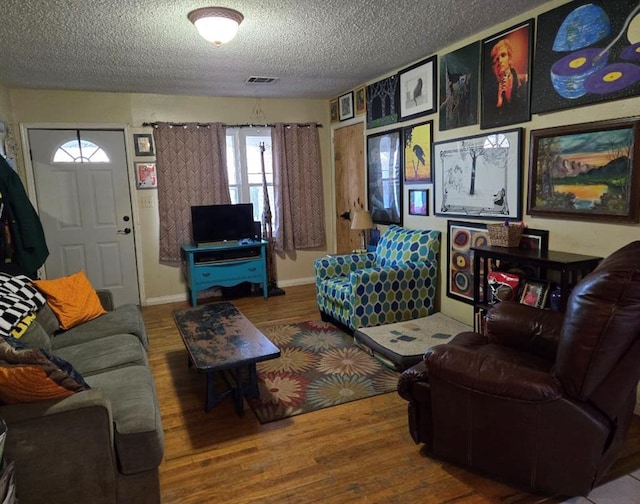 living room with a textured ceiling and hardwood / wood-style floors