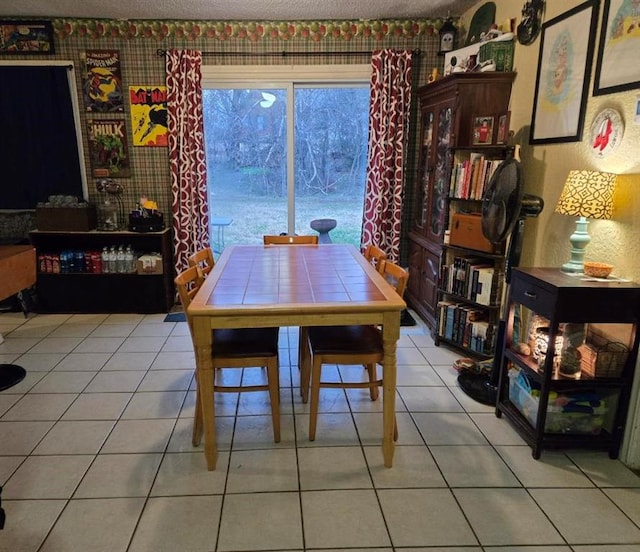 tiled dining room featuring a textured ceiling