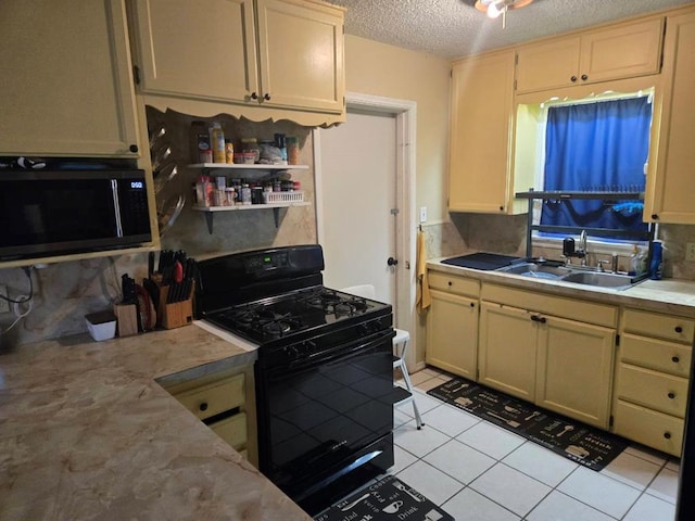 kitchen with light tile patterned floors, decorative backsplash, a textured ceiling, black appliances, and sink