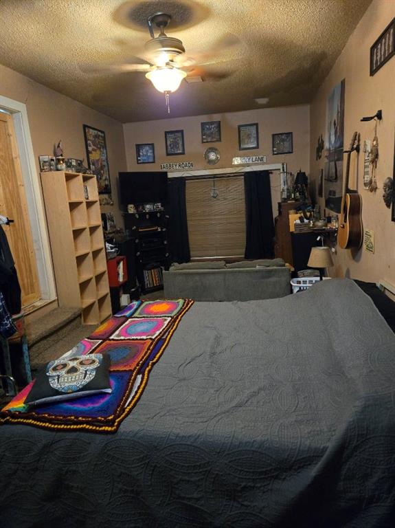 bedroom featuring ceiling fan and a textured ceiling