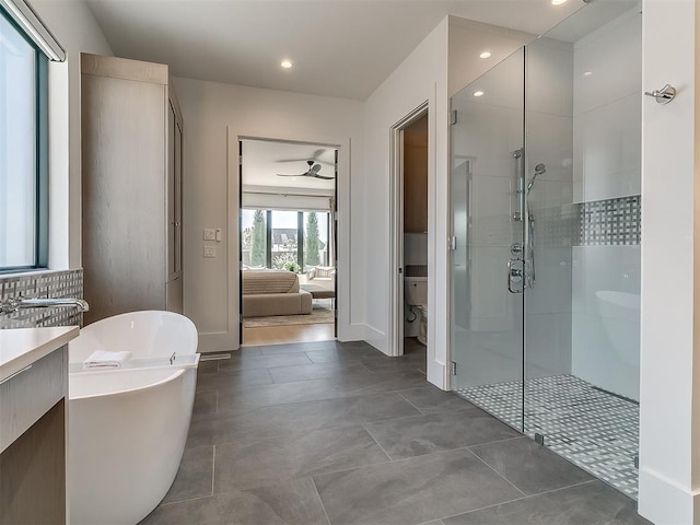 bathroom with ceiling fan, toilet, and plus walk in shower