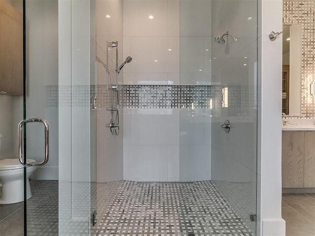 bathroom with tile patterned floors, toilet, walk in shower, and vanity