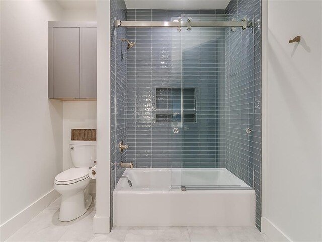 bathroom featuring toilet and shower / bath combination with glass door