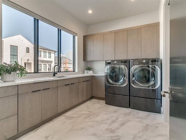 laundry room with sink, separate washer and dryer, and cabinets