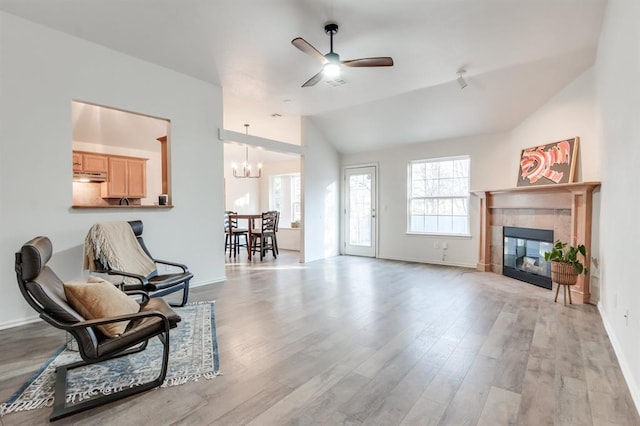 interior space with plenty of natural light, light hardwood / wood-style flooring, lofted ceiling, and a tiled fireplace