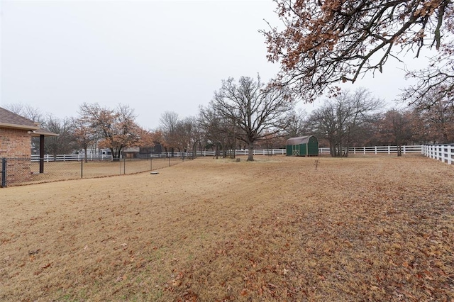 view of yard with a storage unit and a rural view