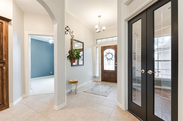 tiled entryway with ornamental molding and french doors