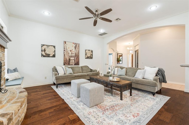 living room with crown molding, ceiling fan, dark hardwood / wood-style flooring, and a fireplace