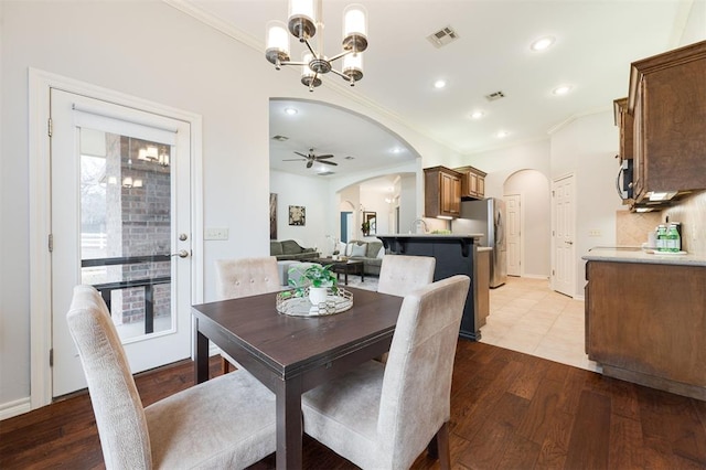 dining space featuring crown molding, sink, ceiling fan with notable chandelier, and light wood-type flooring