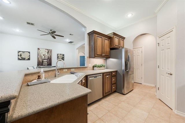 kitchen featuring sink, appliances with stainless steel finishes, ornamental molding, decorative backsplash, and kitchen peninsula