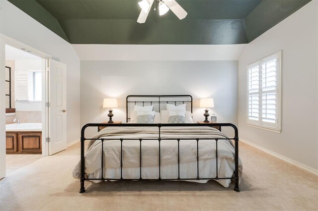 carpeted bedroom with vaulted ceiling and ensuite bath