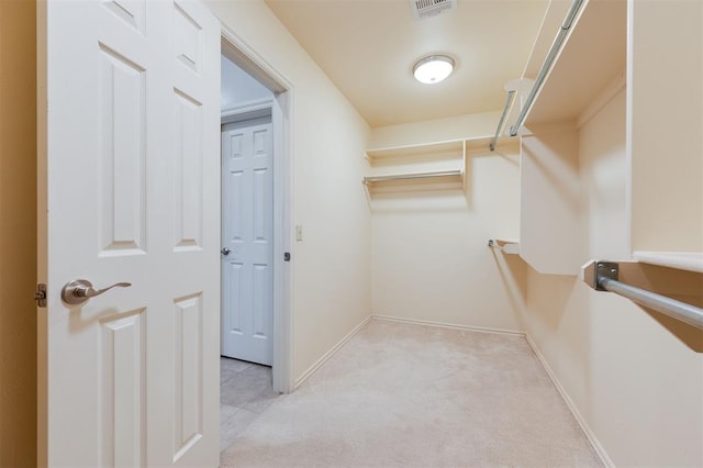 spacious closet featuring light colored carpet