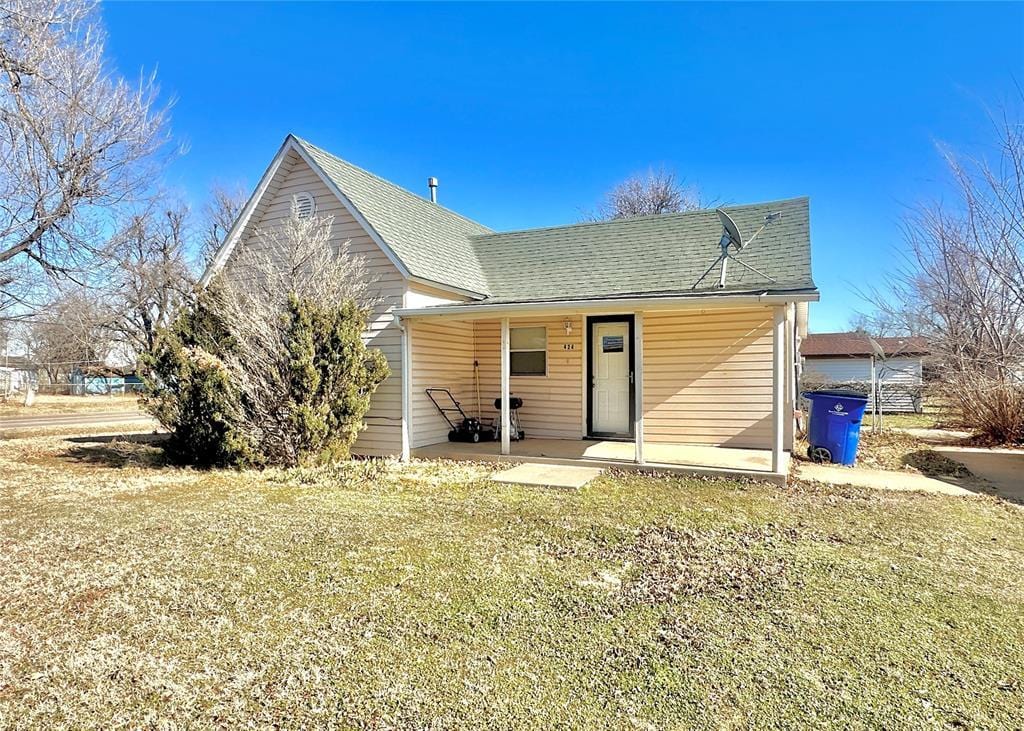 rear view of property featuring a lawn and a patio