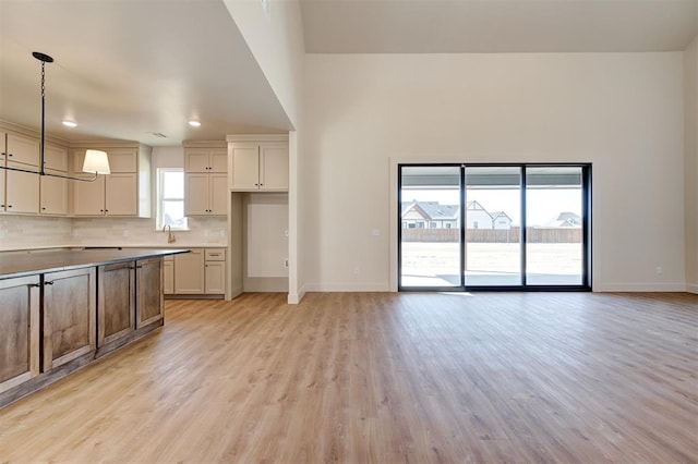 kitchen featuring hanging light fixtures, backsplash, and light hardwood / wood-style floors