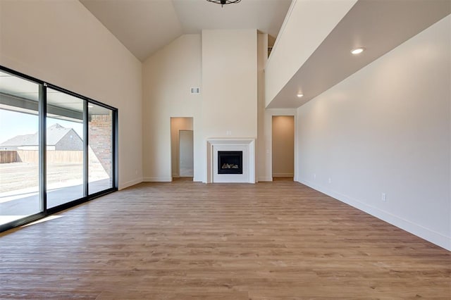 unfurnished living room featuring light hardwood / wood-style floors and high vaulted ceiling