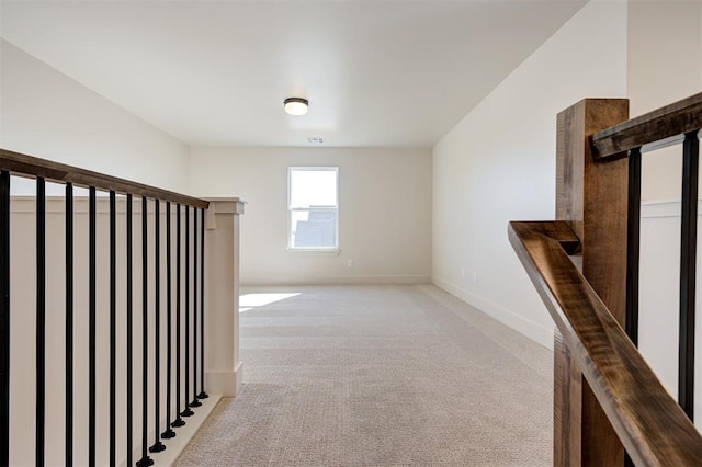 hall featuring light colored carpet