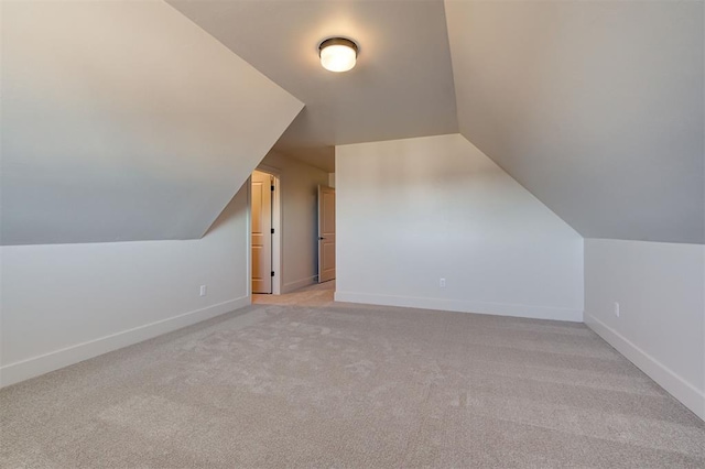 additional living space featuring lofted ceiling and light carpet