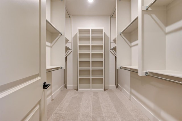 walk in closet featuring light colored carpet