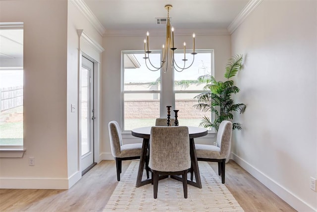 dining room with a notable chandelier, crown molding, and light hardwood / wood-style flooring