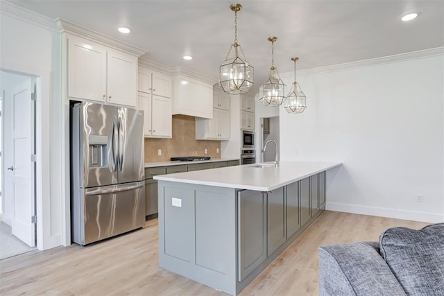 kitchen with white cabinetry, stainless steel appliances, light hardwood / wood-style floors, hanging light fixtures, and crown molding