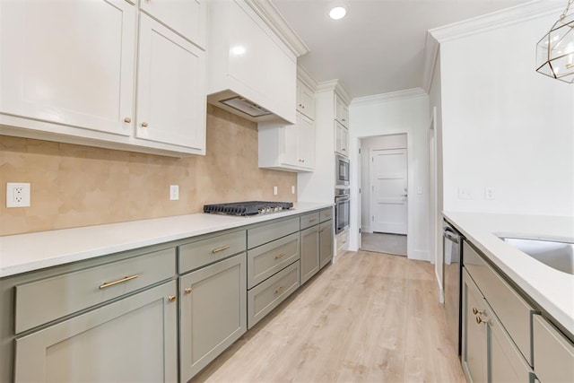 kitchen with white cabinetry, stainless steel appliances, light hardwood / wood-style floors, decorative backsplash, and ornamental molding