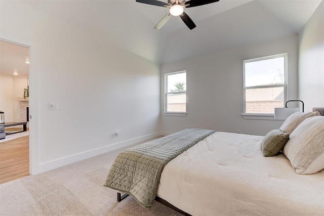 bedroom with ceiling fan, multiple windows, and lofted ceiling