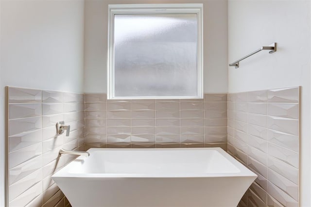 bathroom featuring a tub and tile walls