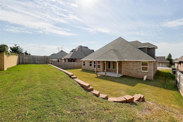 back of house featuring a lawn and a patio