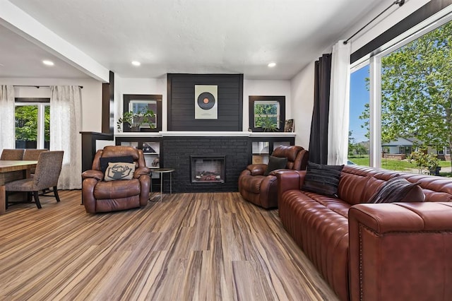 living room with a brick fireplace and light hardwood / wood-style flooring