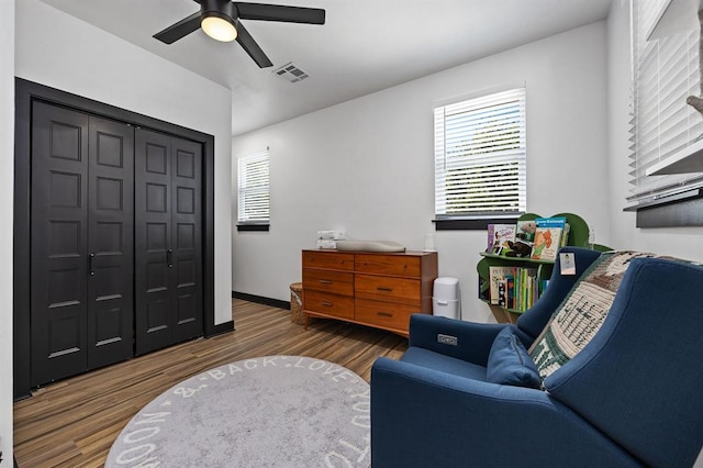 living area featuring ceiling fan and dark hardwood / wood-style floors