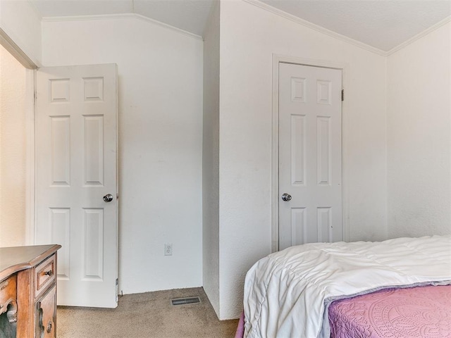 carpeted bedroom featuring ornamental molding and vaulted ceiling