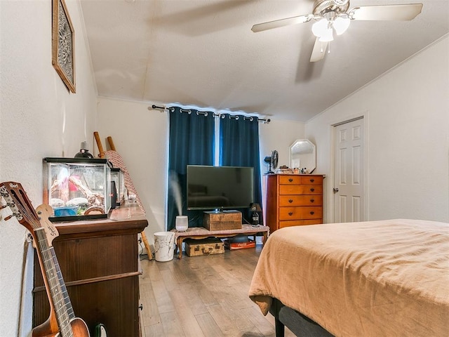 bedroom with ceiling fan, wood-type flooring, and lofted ceiling