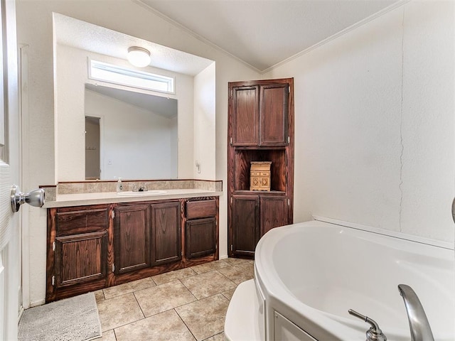 bathroom featuring tile patterned flooring, vanity, a tub, vaulted ceiling, and crown molding