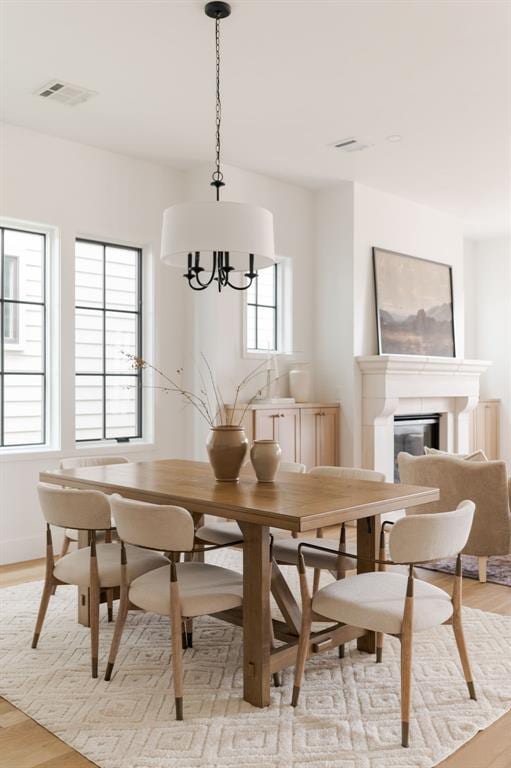 dining area with an inviting chandelier and light hardwood / wood-style floors