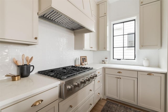 kitchen featuring stainless steel gas stovetop, tasteful backsplash, and custom range hood