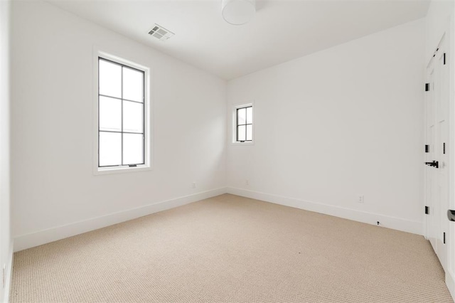 spare room featuring light carpet