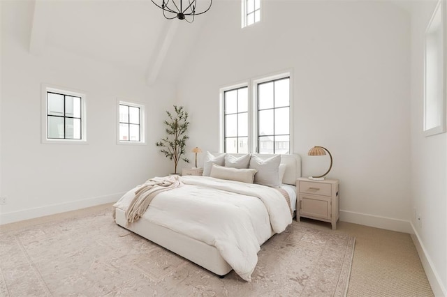 bedroom with a towering ceiling, beamed ceiling, and multiple windows