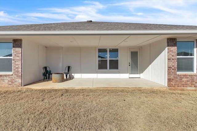 property entrance featuring a patio area and a lawn