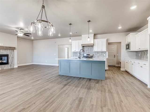 kitchen featuring white cabinets, backsplash, pendant lighting, and appliances with stainless steel finishes