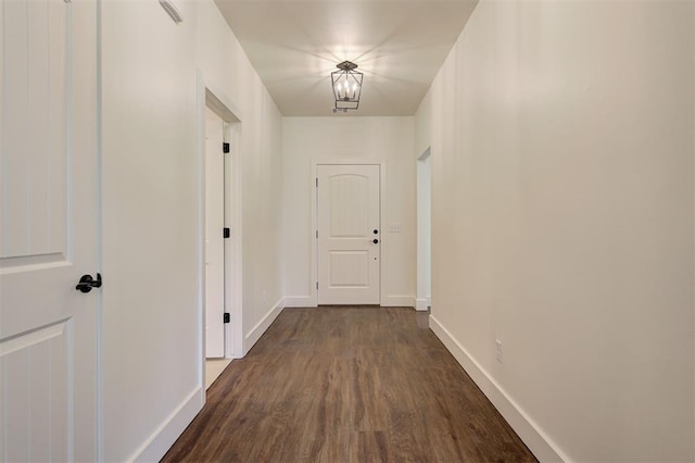 hallway featuring dark hardwood / wood-style floors and a notable chandelier