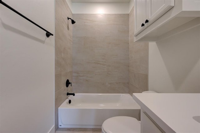 full bathroom featuring toilet, tiled shower / bath, and vanity