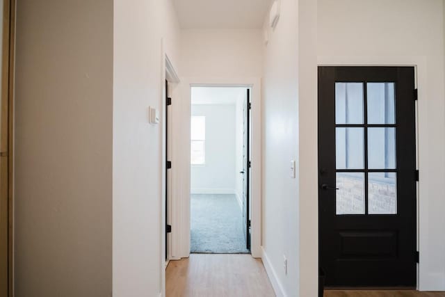 hallway with light hardwood / wood-style floors