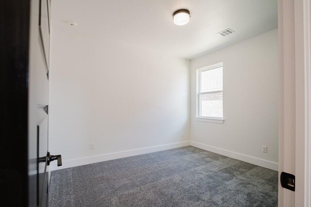 unfurnished room with dark colored carpet