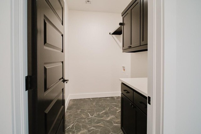 clothes washing area featuring washer hookup and cabinets